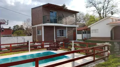 a house with a swimming pool in front of a house at Complejo 