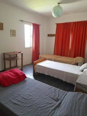 a bedroom with two beds and a red curtain at Complejo 