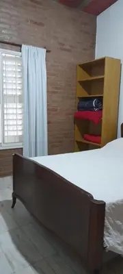 a bedroom with a bed and a dresser and a window at Complejo 