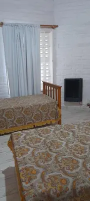 a bedroom with two beds and a flat screen tv at Complejo 