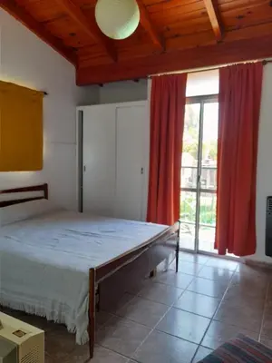 a bedroom with a bed and a large window at Complejo 
