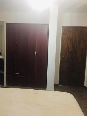 a bedroom with a bed and two wooden cabinets at Benito Soria 137 in Santa Rosa de Calamuchita