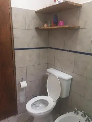 a bathroom with a white toilet and a sink at Benito Soria 137 in Santa Rosa de Calamuchita