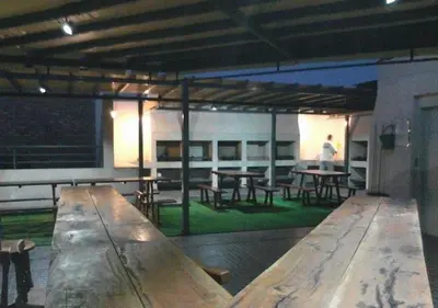 a large wooden table in a room with tables and benches at Departamento Carlos Paz, Centro in Villa Carlos Paz