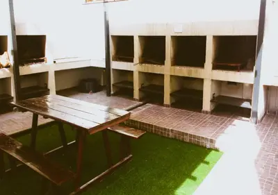 an empty room with a wooden table and green grass at Departamento Carlos Paz, Centro in Villa Carlos Paz