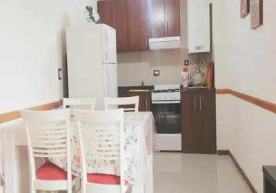 a kitchen with a table and chairs and a refrigerator at Departamento Carlos Paz, Centro in Villa Carlos Paz