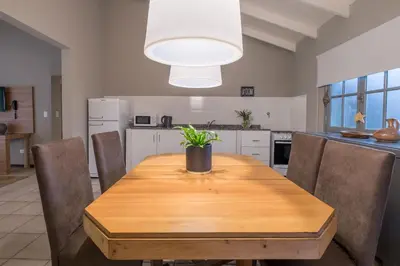 a kitchen with a wooden table with a potted plant on it at Calina Casa de Huéspedes in Villa General Belgrano