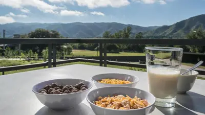 a table with bowls of food and a glass of milk at Calina Casa de Huéspedes in Villa General Belgrano