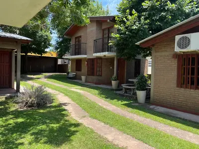 a yard with a building with a fence and grass at Cabañas Los Aromos in Embalse