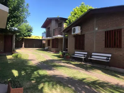 two park benches sitting outside of a building at Cabañas Los Aromos in Embalse