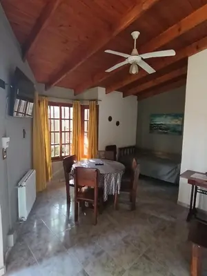 a dining room with a table and a ceiling fan at Cabañas Los Aromos in Embalse
