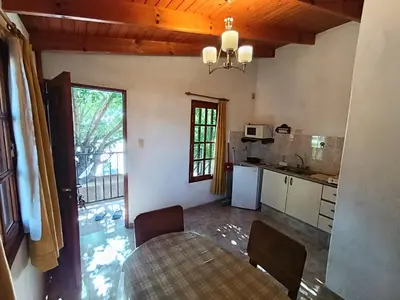 a kitchen with a table and a dining room at Cabañas Los Aromos in Embalse
