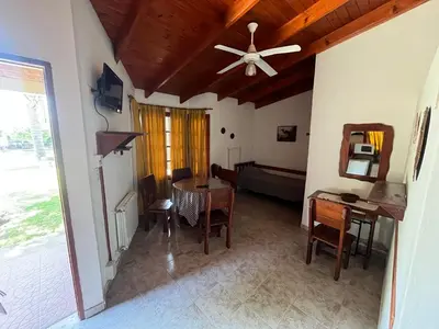 a living room with a ceiling fan and a table at Cabañas Los Aromos in Embalse