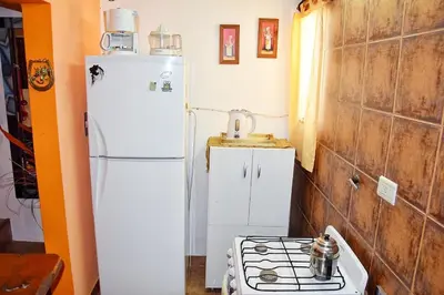 a kitchen with a white refrigerator and a stove at CASA FRENTE AL RIO Playas de Oro in Villa Carlos Paz