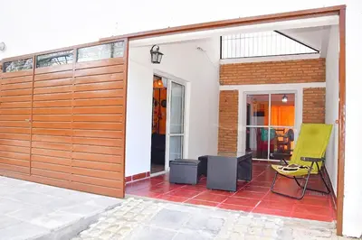 a wooden garage door with a green chair on a patio at CASA FRENTE AL RIO Playas de Oro in Villa Carlos Paz