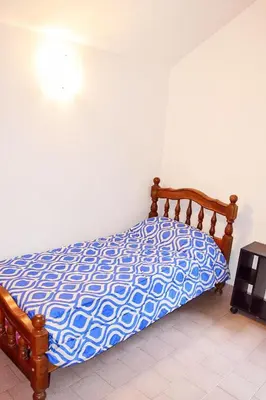 a bed with a blue and white comforter in a bedroom at CASA FRENTE AL RIO Playas de Oro in Villa Carlos Paz