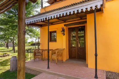 a porch of a house with a table and chairs at Cabañas La Matera in Los Reartes