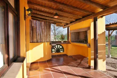 a porch of a house with yellow walls at Cabañas La Matera in Los Reartes