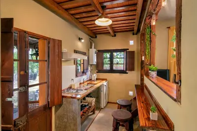 a kitchen with wooden ceilings and a counter with stools at Cabañas La Matera in Los Reartes