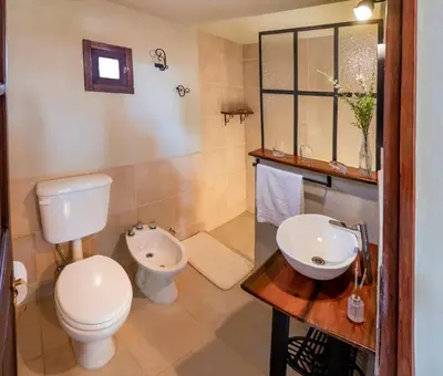 a bathroom with a toilet and a sink at Cabañas La Matera in Los Reartes