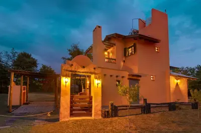 a house with a staircase leading up to it at night at Cabañas La Matera in Los Reartes