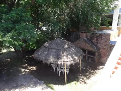 a table and chairs under a straw umbrella at Rincón del Valle in Mina Clavero