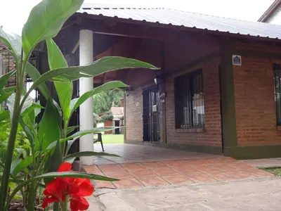 a brick building with a porch with a red flower at Rincón del Valle in Mina Clavero