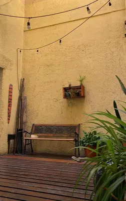 a bench sitting next to a wall with a window at Go Hostel in Cordoba