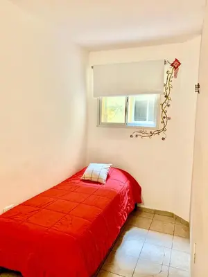 a red bed in a room with a window at Go Hostel in Cordoba