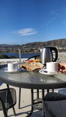 a table with a plate of food and coffee cups at Domus Lake Resorts in Villa Carlos Paz