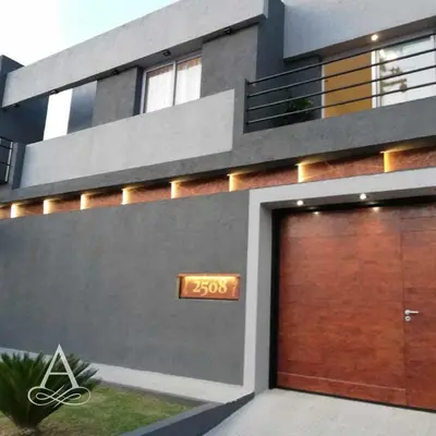 a building with a garage with a sign on it at Altos de Chacabuco Planta Alta Apartamento temporario amoblado premium con cochera gratis in Cordoba