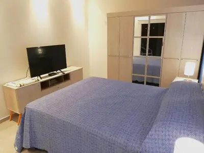 a bedroom with a blue bed and a television at Altos de Chacabuco Planta Alta Apartamento temporario amoblado premium con cochera gratis in Cordoba