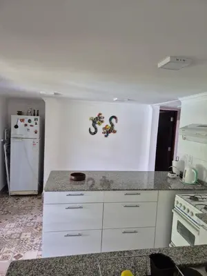 a kitchen with white cabinets and a white refrigerator at Doña Haydee in Las Tapias