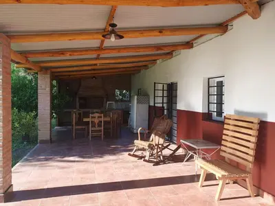 a patio with a wooden pergola and chairs at Doña Haydee in Las Tapias