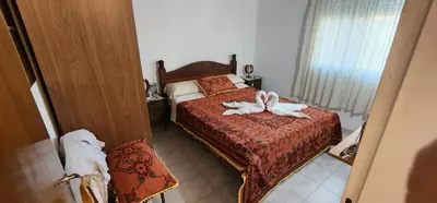 a bedroom with a bed with two towels on it at Hermoso Chalet en Nono in Nono