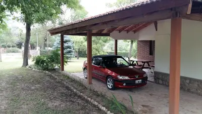 a small red car parked under a shed at Hermoso Chalet en Nono in Nono