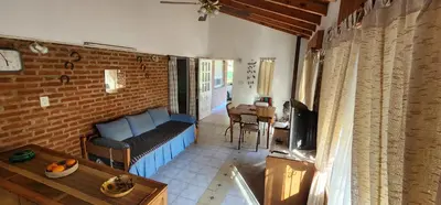 a living room with a blue couch and a table at Hermoso Chalet en Nono in Nono