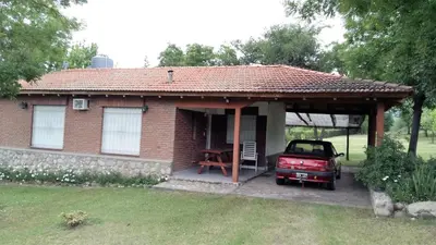 a red car parked in front of a small house at Hermoso Chalet en Nono in Nono