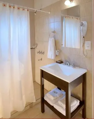 a bathroom with a sink and a shower with a shower curtain at El Portillo in Villa General Belgrano