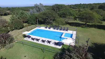 an overhead view of a swimming pool with horses by it at El Portillo in Villa General Belgrano