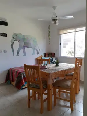 a dining room with a table and chairs and an elephant on the wall at COSTA COM Departamentos de Montaña in Merlo