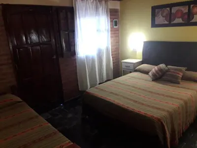 a hotel room with two beds and a window at Hosteria Santa Francisca in Villa Cura Brochero