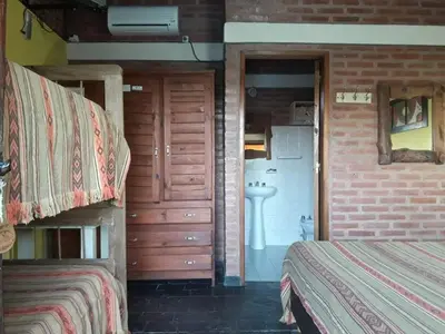 a bedroom with two bunk beds and a bathroom at Hosteria Santa Francisca in Villa Cura Brochero
