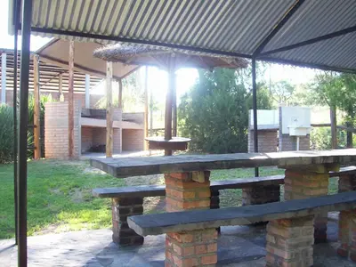 a picnic table with an umbrella on a patio at Hosteria Santa Francisca in Villa Cura Brochero