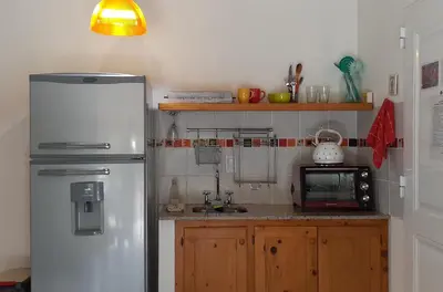 a kitchen with a white refrigerator and a microwave at COSTA COM Departamentos de Montaña in Merlo