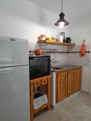 a kitchen with a white refrigerator and a microwave at COSTA COM Departamentos de Montaña in Merlo