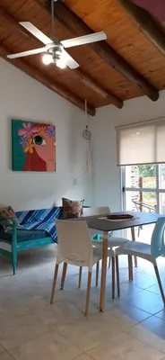 a dining room with a table and chairs and a bed at COSTA COM Departamentos de Montaña in Merlo