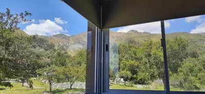 a window with a view of a horse in a field at COSTA COM Departamentos de Montaña in Merlo