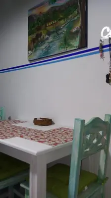 a table with a chair and a picture on the wall at Departamento MT 2 Barrio Jardín in Cordoba