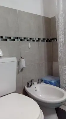 a bathroom with a white toilet and a sink at Departamento MT 2 Barrio Jardín in Cordoba